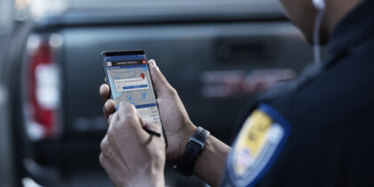 A law enforcement officer using a smartphone for field work