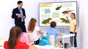 Teacher gives student feedback using interactive whiteboard in classroom